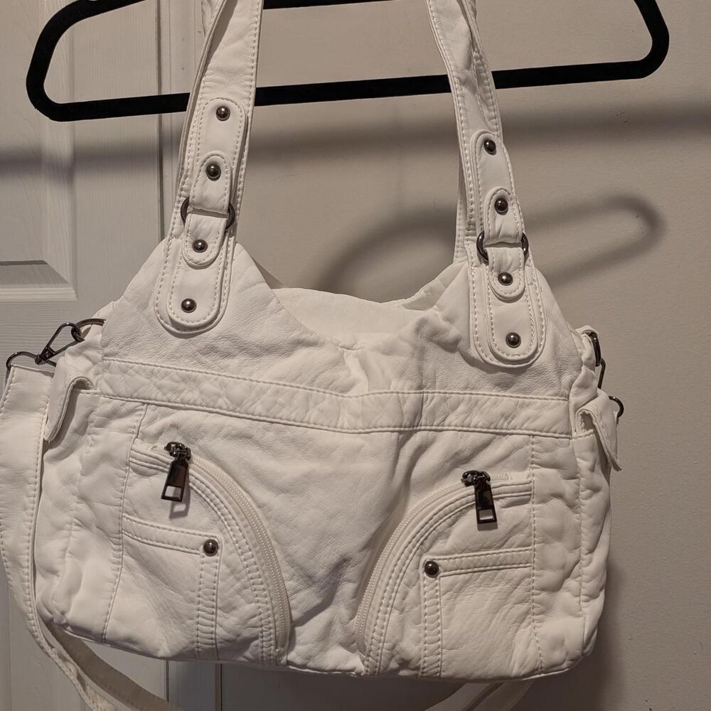 White leather handbag with multiple pockets and adjustable straps